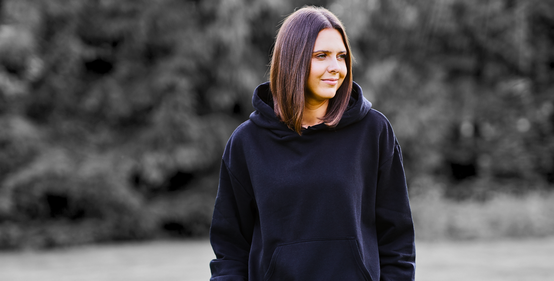 A girl wearing a black hoodie in the park