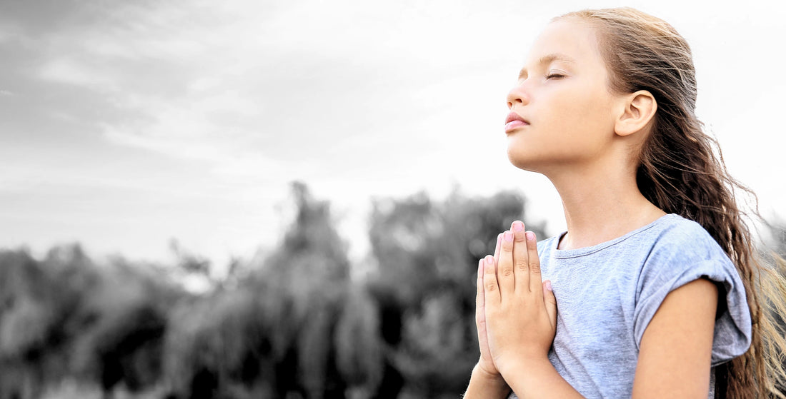 Young girl praying to God outside