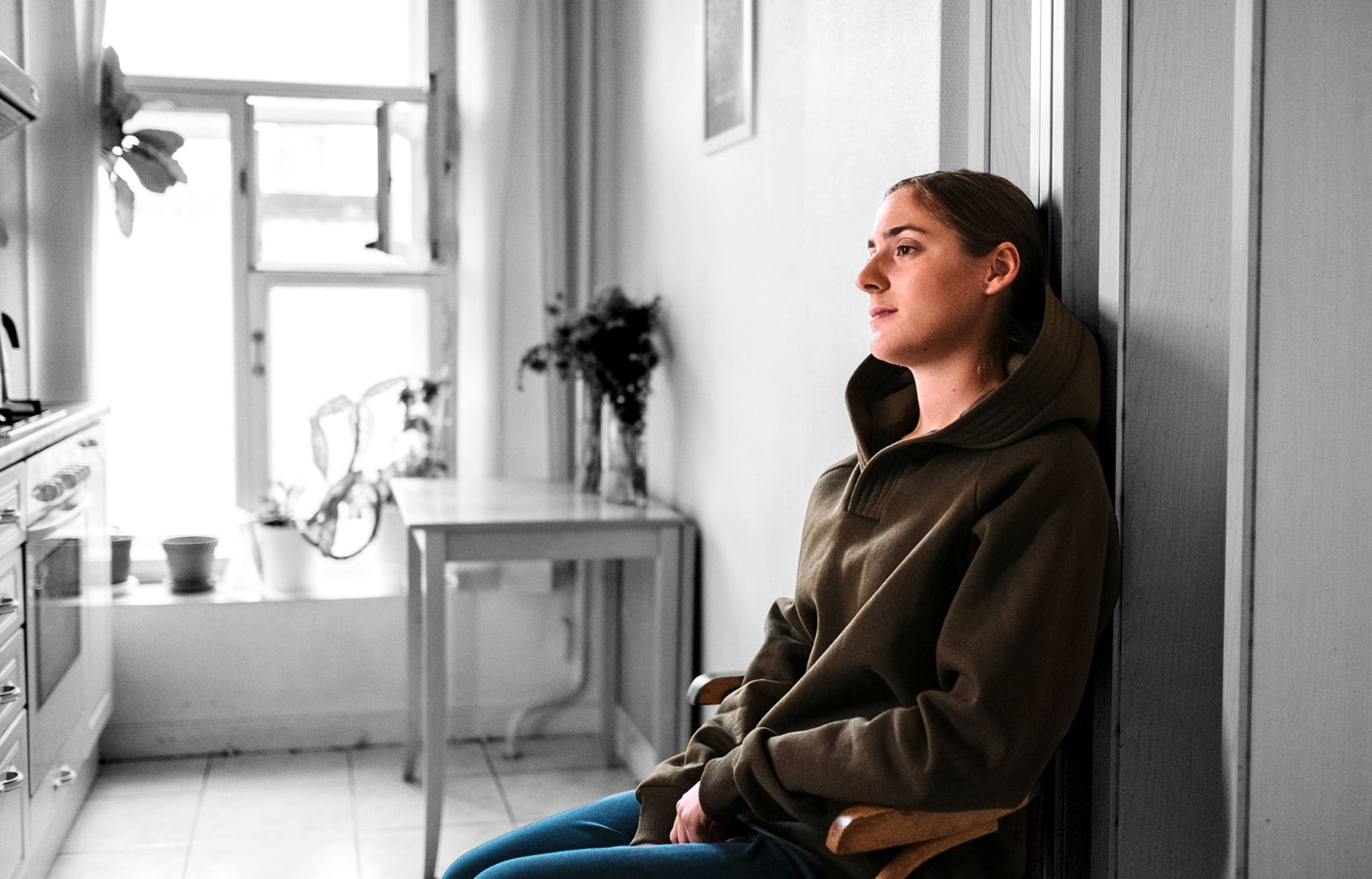 Girl depressed at home wearing a olive hoodie