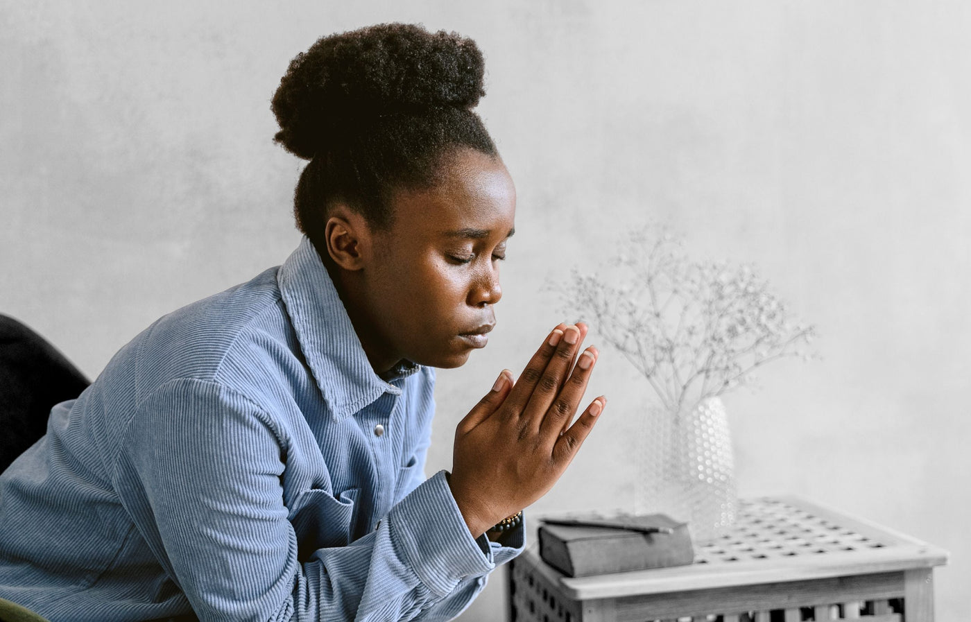 Women praying beside her bed for her husband
