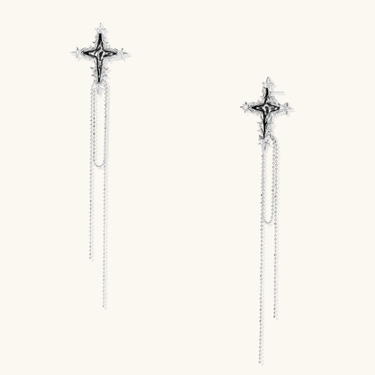 Long silver threader earrings with ornate cross-star design and delicate dual chain tassels on white background